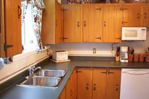 The clean and tidy kitchen is well equipped with good appliances and stainless steel pots and pans.