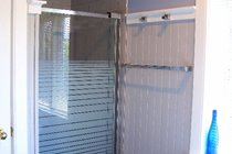 The bathroom also features a glassed-door shower stall.