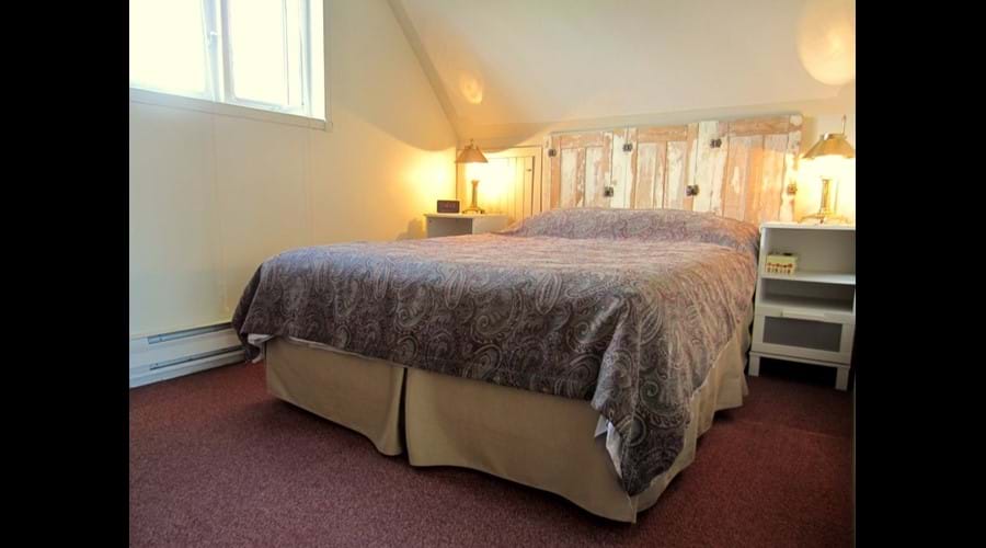 The second bedroom located on the top floor in the main cottage is furnished with a comfortable queen-sized bed.
