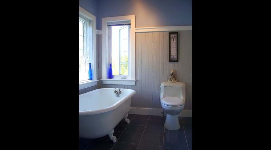 The spacious main bathroom on the upper level was completely remodeled and features a deep re-glazed bath tub