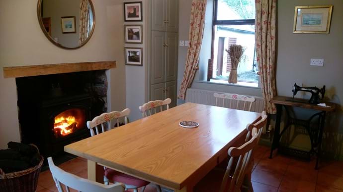 Dining room with the warm glow of a blazing stove while you note the leisurely pace of country life.