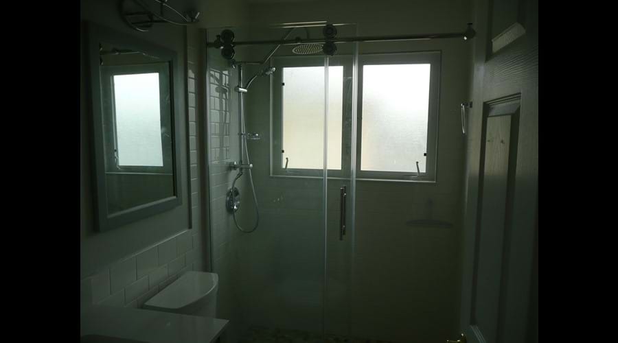 newly remodelled family bathroom with new vanity, mirrors, lights and large shower with seperate handspray