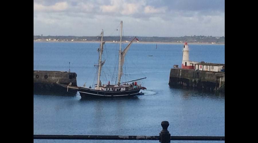 Long boat arriving in Newlyn harbour