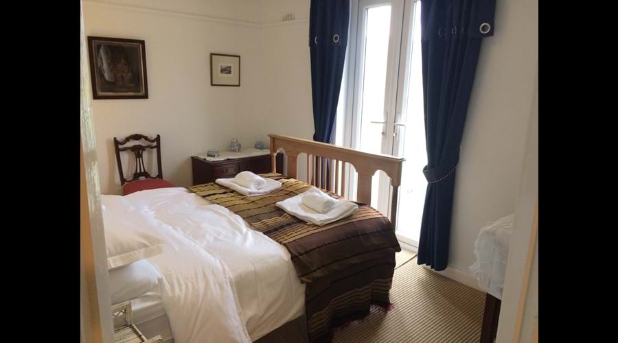 Stylish Double bedroom leading to glass balcony with panoramic views of Sea & valley