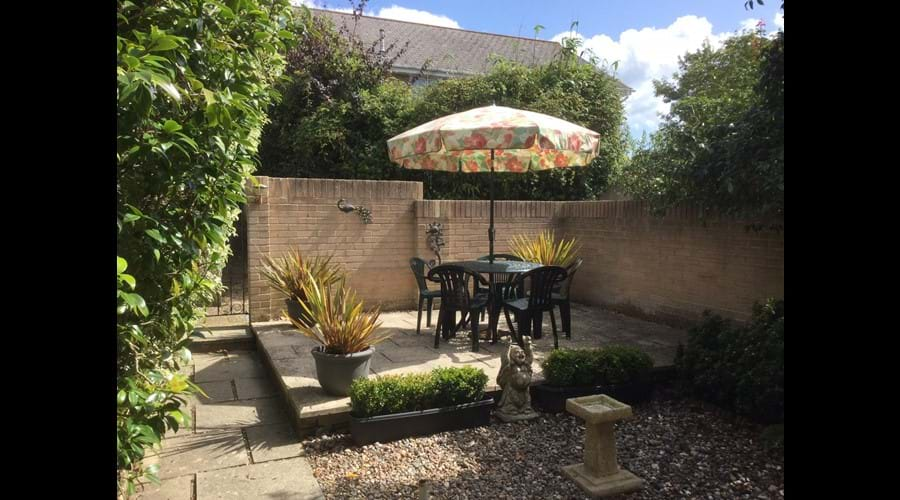 Sunny rear walled garden - wire mesh dog guard on gate.