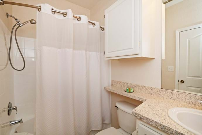 Master Bathroom with shower over bathtub, toilet and washbasin