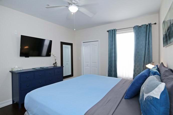 The Master Bedroom at our 4 bedroom condo with walk in closet, 46" TV, chest of drawers, ceiling fan and air con and en suite bathroom