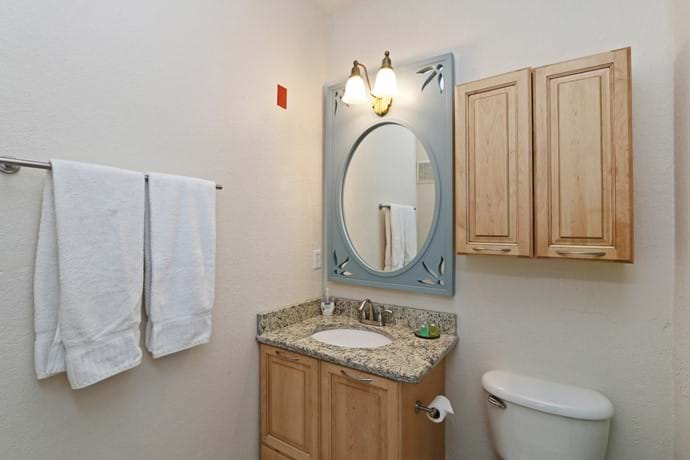 Master Bathroom with Disney Princess Mirror, shower over bathtub, toilet and washbasin.  4 bedroom condo 13-102