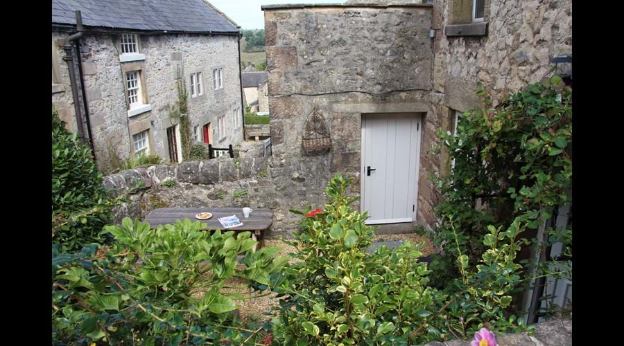 The pretty walled garden has herbaceous plants and a bay tree surrounded by traditional Derbyshire stone walls.