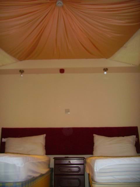 Inside a pod with draped linen ceiling and two single beds