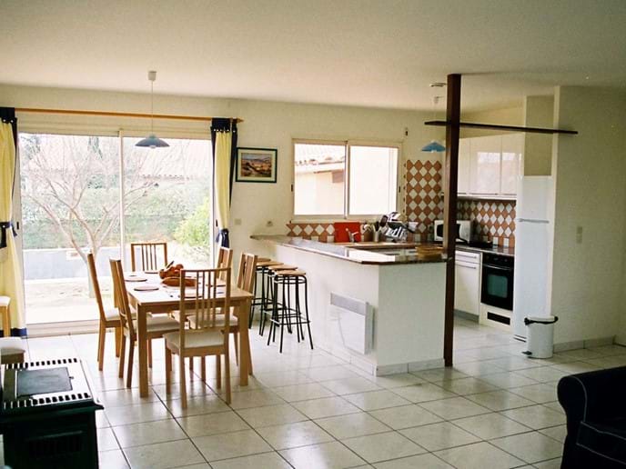 Moderne, eingerichtete Küche mit Granit gekrönt Frühstück Bar, und Esszimmer mit Terrassentüren mit Blick auf die Terrassen, Pool und Garten.