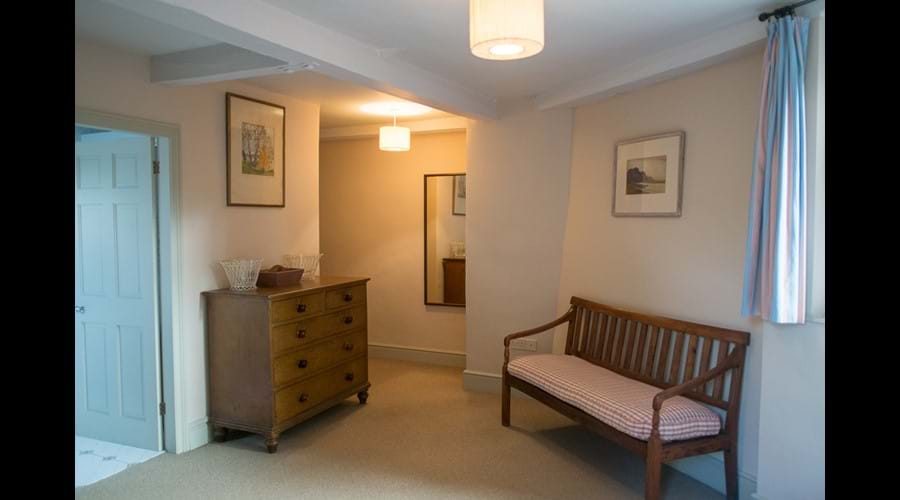 A corner of a ground floor bedroom, door through to en-suite shower-room.