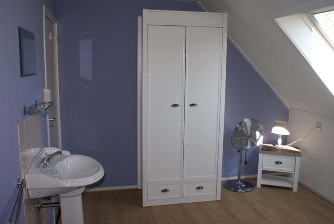 One of the twin bedrooms with a basin and wardrobe