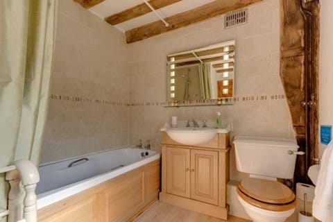 Family bathroom with over-bath power shower and magic heated mirror whose lights turn on at the wave of a hand...