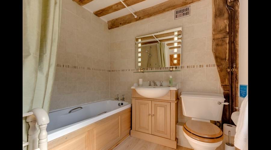 Family bathroom with over-bath power shower and magic heated mirror whose lights turn on at the wave of a hand...