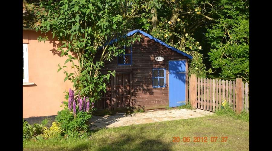 Playhouse in the garden…lawnmower and ironing board inside