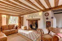 The beamed sitting room, with a log burner in the inglenook fireplace.