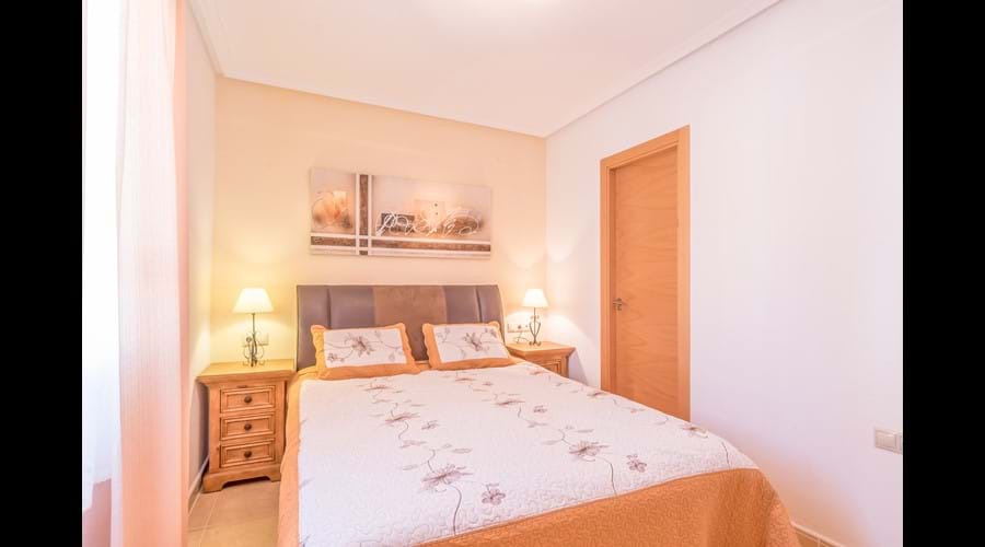 Main bedroom with large fitted wardrobe & storage chests, bedside locker and full-length mirror