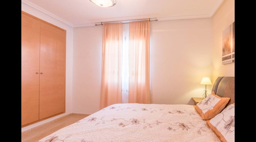 Main bedroom with large fitted wardrobe & storage chests, bedside locker and full-length mirror