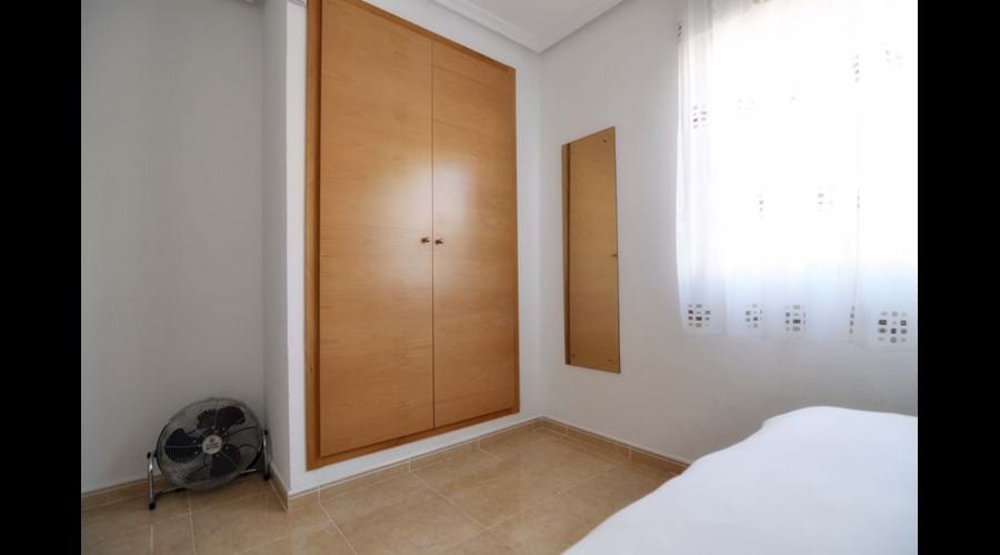 Main bedroom with large fitted wardrobe & storage chests, bedside locker and full-length mirror