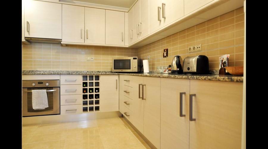 Large Kitchen inc ceramic hob, electric oven, fridge freezer and storage from end to end.