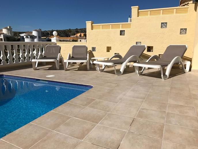 Four sun loungers on the pool terrace
