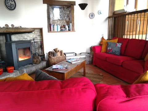 Cosy living room with 2 large sofas and a woodburner