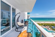 "Two comfortable swing chairs admire the fantastic South Beach View! "