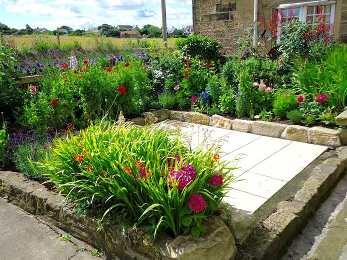 The front garden is a typical cottage garden, bursting with colour in the summer