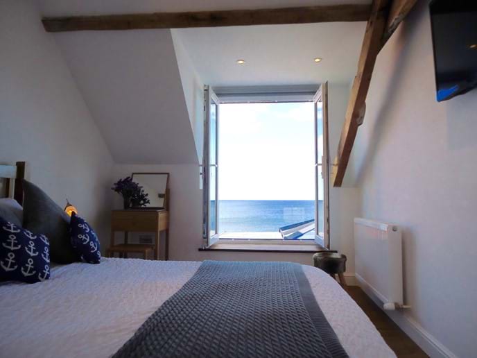 The master bedroom has a king-sized bed and a wall-mounted TV, as well as a stunning panoramic sea view