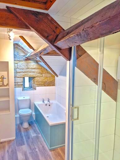 The bathroom has a bath and shower, and even offers a sea view through the quirky arrow-slit window