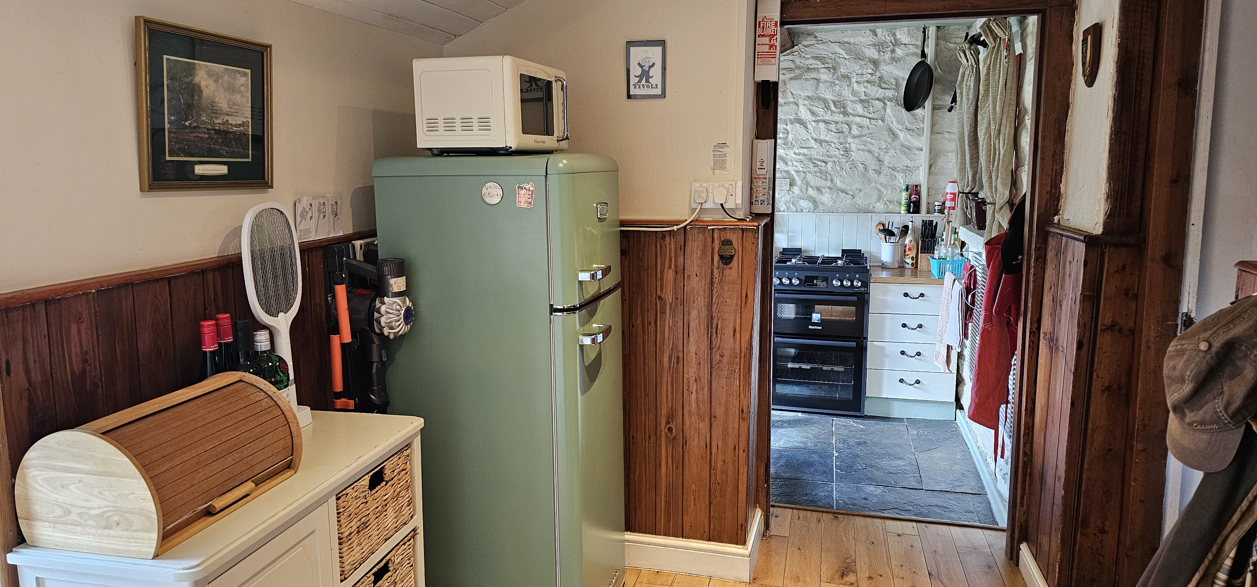 The utility area with fridge freezer and microwave as well as cupboards for food storage