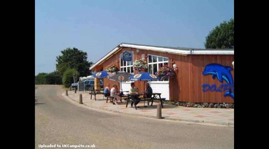 The Dolphin Bar, 150 yards away. Open March-Nov. Serves great snacks, beer, coffee etc, Dogs allowed inside