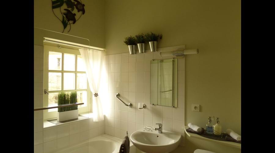 Bright bathroom with shower/bath, basin, W.C. and hairdryer