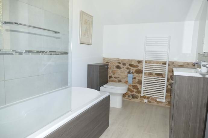 En suite for Bedroom Three has a bath with a shower over
