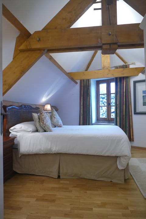 This bedroom is also open to the rafters with exposed beams