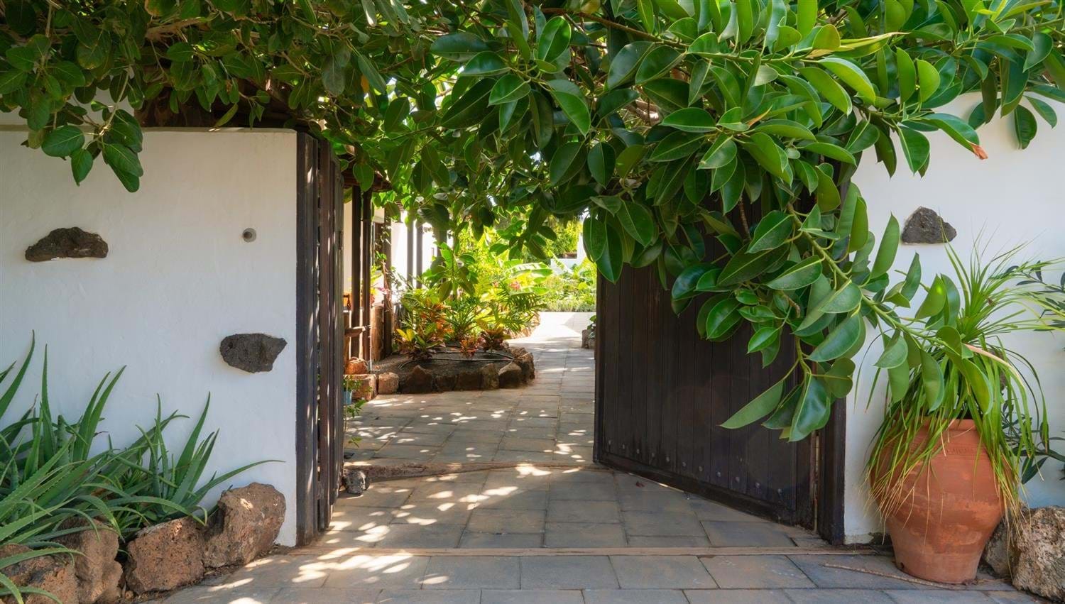 Large old wooden gate opening into The Secret Garden Villa at Finca Botanico in Lanzarote