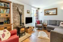 Contemporary Open Plan Lounge with exposed Stone Wall and Woodburner