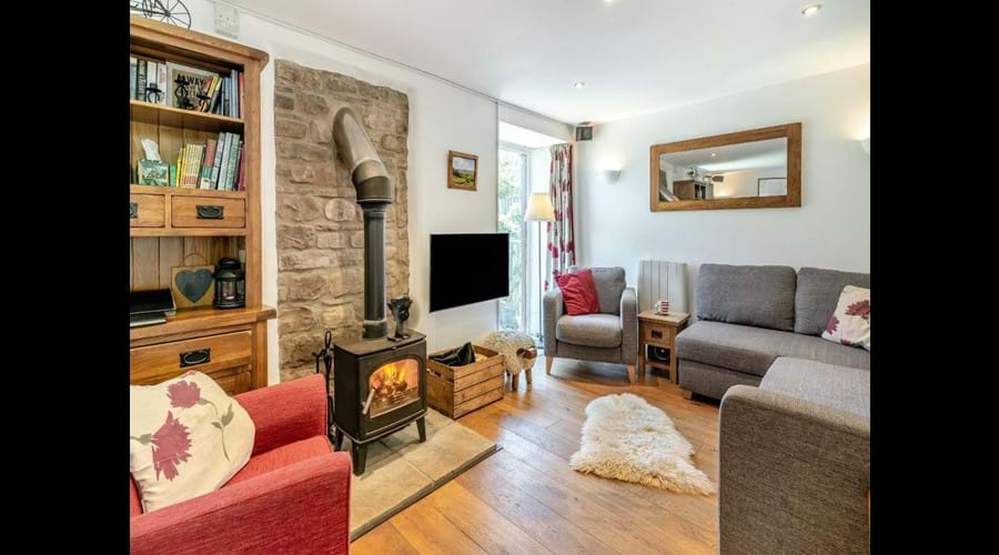 Contemporary Open Plan Lounge with exposed Stone Wall and Woodburner