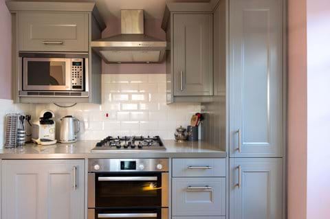 Kitchen with gas hob, electric oven and microwave.