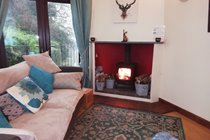 Living space with Smart TV, Aga log burner and French doors out onto a raised terrace