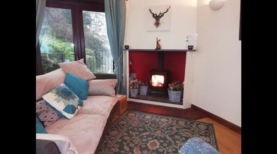 Living space with Smart TV, Aga log burner and French doors out onto a raised terrace