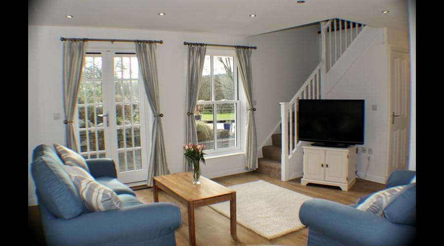Cosy living area with French windows to patio and garden