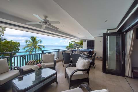 Balcony with sea view at Coral Cove 12. Armchairs, dining area, hot tub.