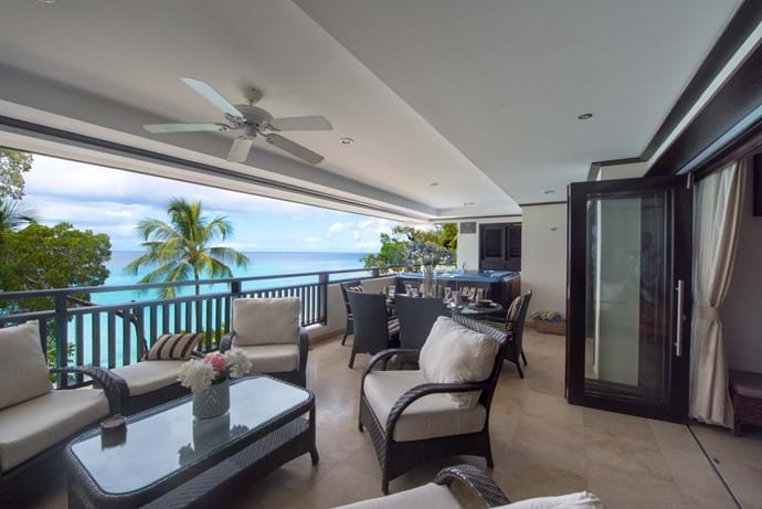Seating area with coffee table on the balcony of Coral Cove 12. Views of Paynes bay beach and they Caribbean Sea.