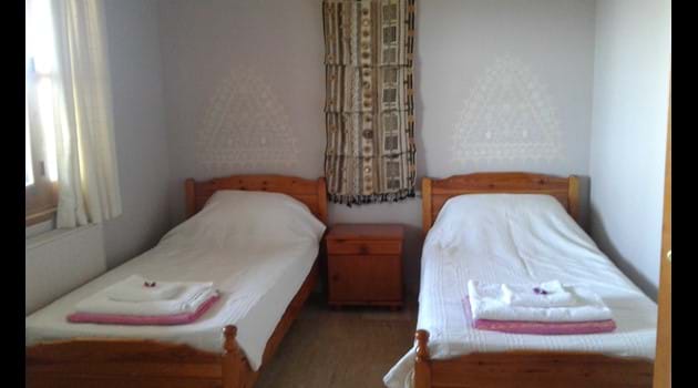 Second bedroom with twin beds and french windows to the terrace