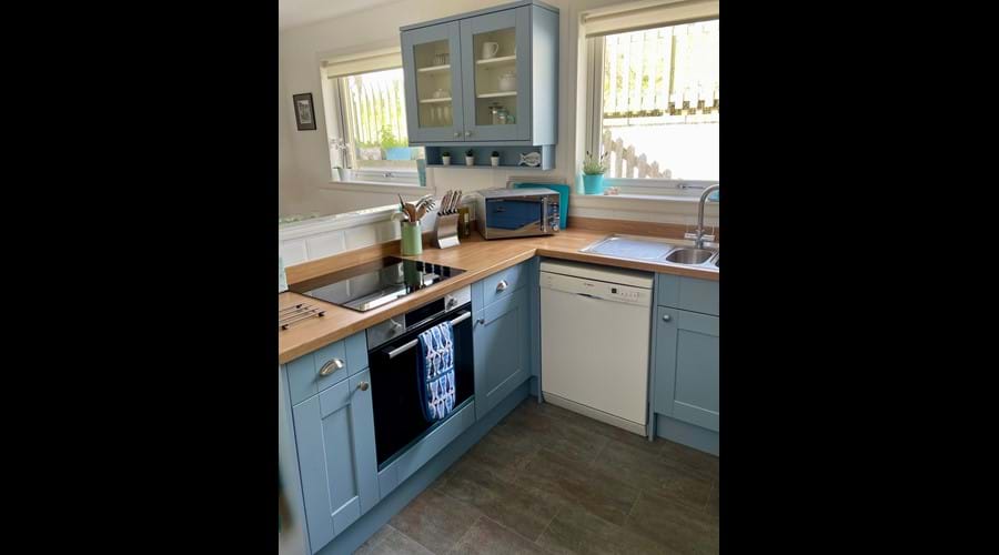 Well equipped kitchen with dishwasher, oven, hob, microwave, fridge plus large fridge freezer and washing machine and dryer in utility area