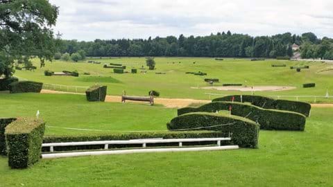 A small white fenced jump on the very green racecourse surrounded by trees in Arnac Pompadour 