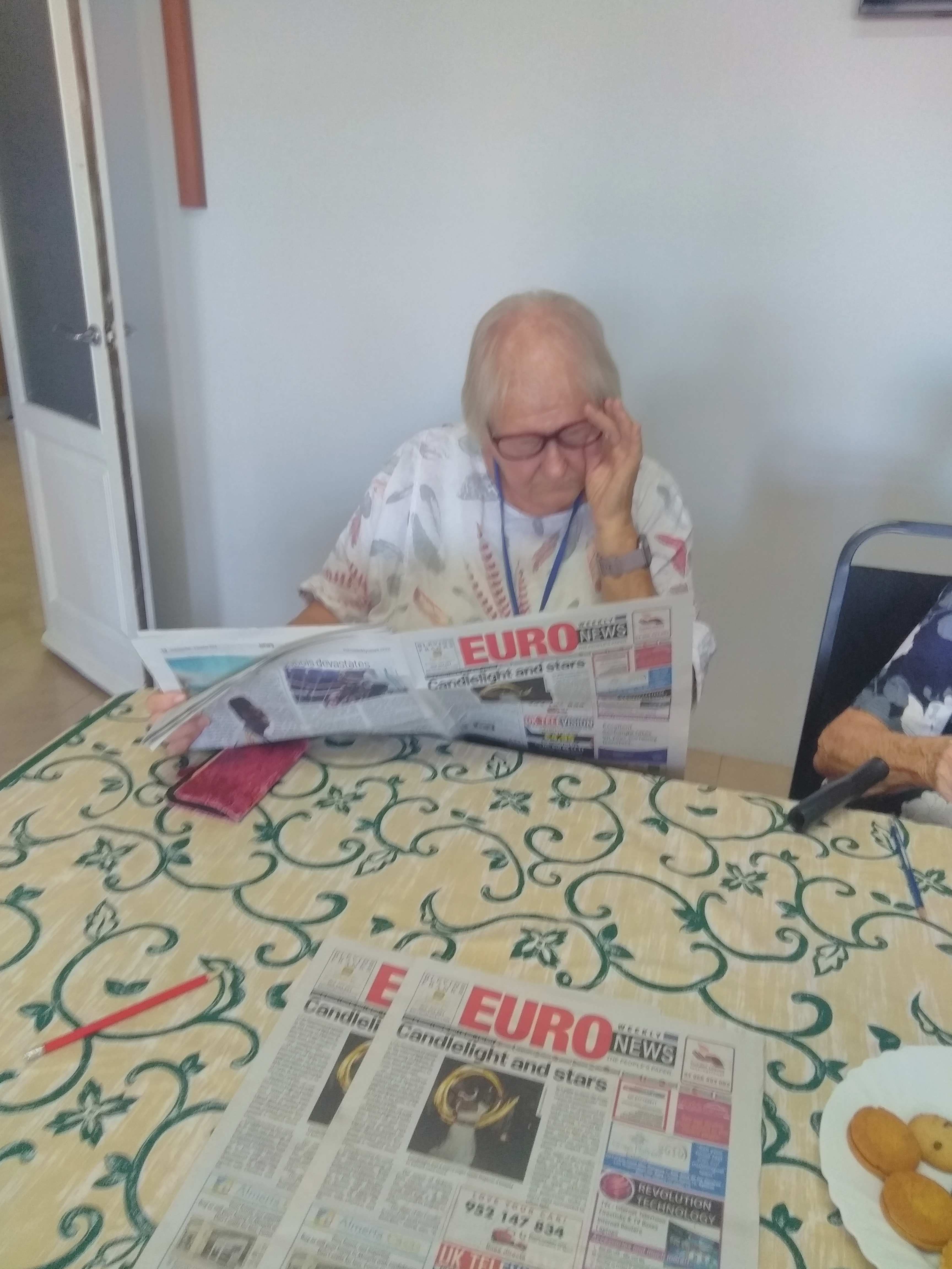 Ann studying the Euro Weekly.