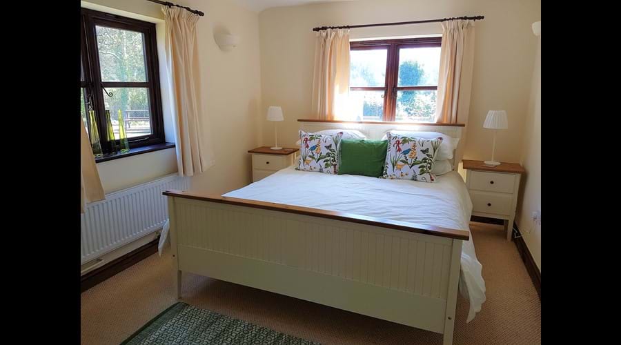 Bright, airy King Sized bedroom with garden views from both windows. 